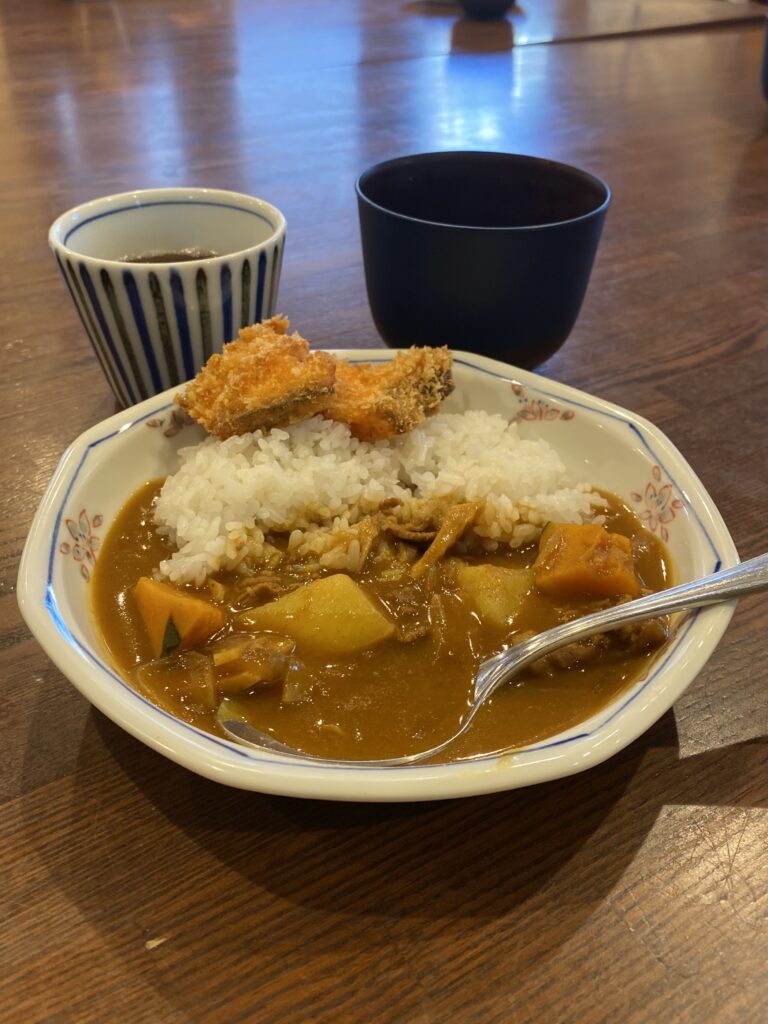 鮭フライ付きカレーとお味噌汁の写真